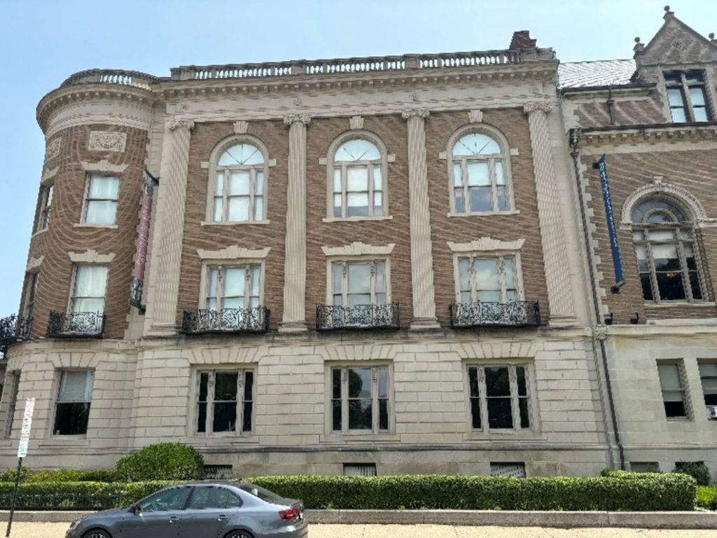 A modern photo of the western side of the Massachusetts Historical Building, with a stone exterior on the ground floor and brick exterior for upper floors. It is decorated with pilasters, windows, and balconettes.