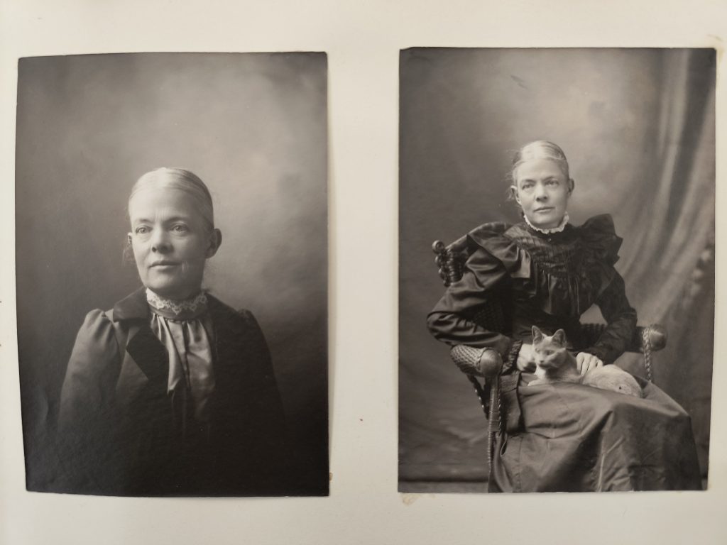 Two black-and-white studio portrait photographs of a white woman with gray hair. The photograph on the left is a close-up, and the photograph on the right depicts her seated with a cat on her lap. In both photographs, her hair is tied back behind her head, and she is dressed in dark clothing.