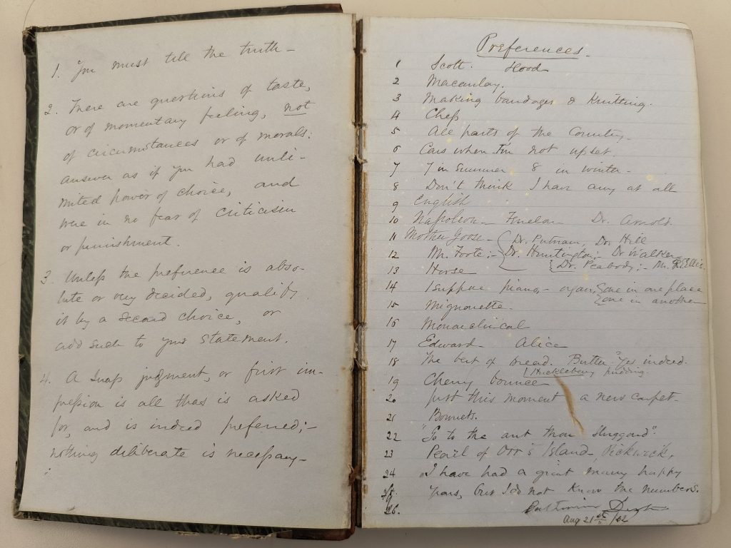 Color photograph of two pages of an open hardbound leather volume. The pages are blue and covered with handwriting in black ink. The left page contains four numbered paragraphs beginning with “1. You must tell the truth,” and the right page contains a list of 24 items under the heading “Preferences.” The binding of the volume is worn, stained, and separating from the spine.