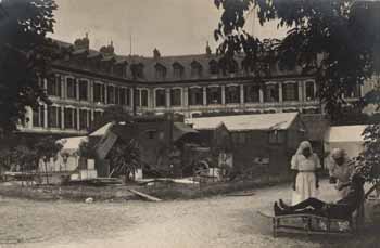 Members of Mrs Daly`s Unit tending to one soldier in front of the Angicourt hospital Photograph