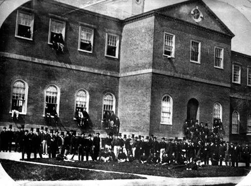 Many men standing in front of a building Lantern slide