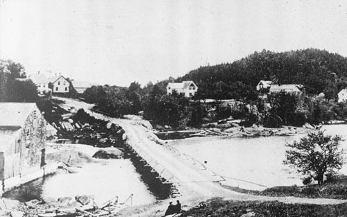 A bridge over a river with houses on either side Lantern slide