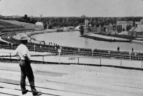 A man standing looking over a river Lantern slide