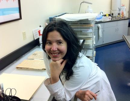 Photograph of Oona  Beauchard leaning on light table in  conservation lab